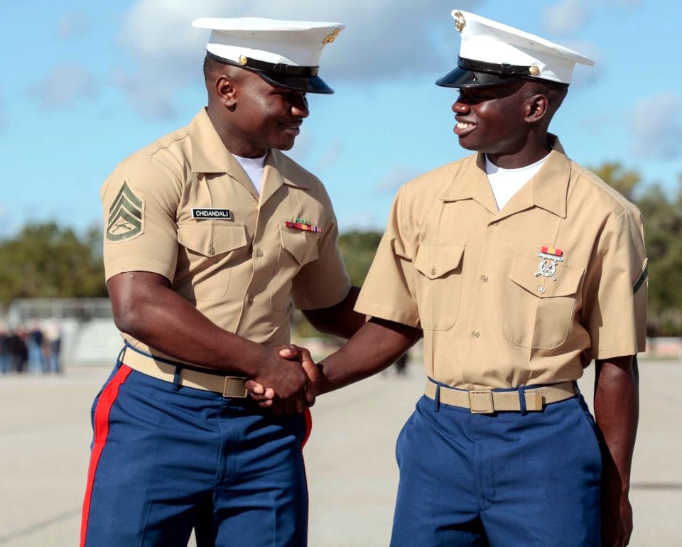 U.S. Marine Corps Staff Sgt. Fidel Chidandali, a canvassing recruiter at Recruiting Substation Gastonia, Recruiting Station Charlotte, congratulates younger brother, Pfc. Ushindi Phanuel, for graduating from recruit training at Marine Corps Recruit Depot Parris Island, South Carolina on October 29, 2021. Chidandali and Phanuel are the first two people in their family to become United States Marines. As a teenager, Chidandali decided he wanted to become a United States Marine after his first encounter with a Marine Corps Security Guard at the U.S. Embassy in Kenya. (Courtesy photo by U.S. Marine Corps Sgt. Dana Beesley)