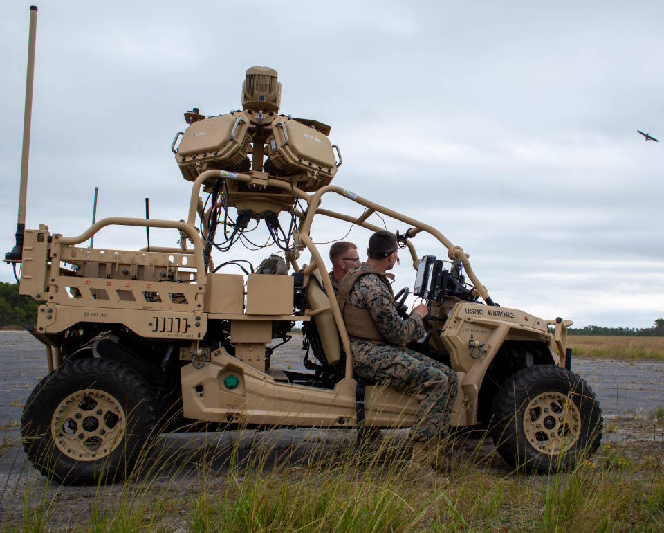 U.S. Marine Corps Lance Cpl. Kevin Holdaway (left) and Cpl. Seth Silveira, low-altitude air-defense gunners with 2nd Low Altitude Air Defense Battalion (LAAD), send an electronic signal to jam a drone with the Light Marine Air Defense Integrated System, or L-MADIS, at Marine Corps Outlying Landing Field Atlantic, North Carolina, Oct. 18, 2022. The L-MADIS is an electronic-attack system that counters unmanned-aircraft system by nonkinetic capabilities to destroy or negate aerial threats. 2nd LAAD is a subordinate unit of 2nd Marine Aircraft Wing, the aviation combat element of II Marine Expeditionary Force. (Image created by USA Patriotism! from U.S. Marine Corps photo by Sgt. Servante R. Coba.)